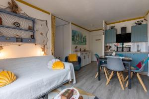 a bedroom with a bed and a desk and a kitchen at Studio cabine centre ville in Arcachon