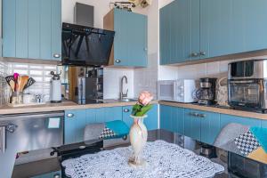a vase with a flower on a table in a kitchen at Studio cabine centre ville in Arcachon +9 photos