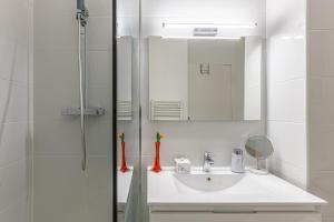 a white bathroom with a sink and a mirror at Studio cabine centre ville in Arcachon