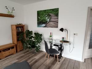a living room with a table and a desk with a plant at Ferienwohnung Papperitz in Heiligen