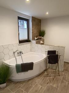a large bathroom with a tub and two chairs at Ferienwohnung Papperitz in Heiligen