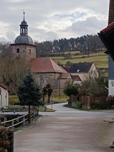 a church with a tower with a clock on it at Ferienwohnung Papperitz in Heiligen