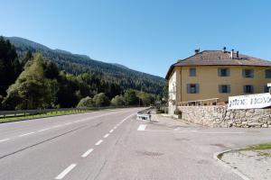 a road with a building on the side of it at Appartamenti Ride Home in Commezzadura
