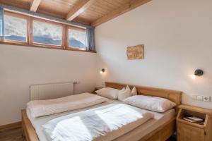 a bedroom with two beds and a window at Kranebitterhof Apt Alpenrose in Valdaora