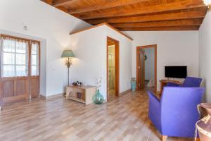 a living room with a blue chair and a television at Las Casas del Bisa in Garachico