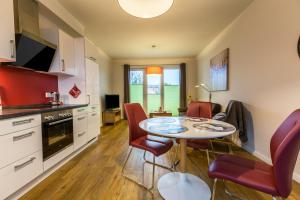a kitchen and dining room with a table and chairs at Ferienwohnung Büsumperle weiß in Büsum +12 photos