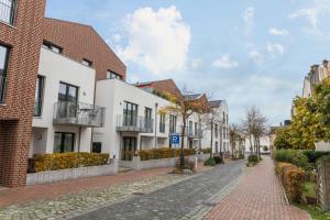 a cobblestone street in a town with white houses at Ferienwohnung Büsumperle weiß in Büsum