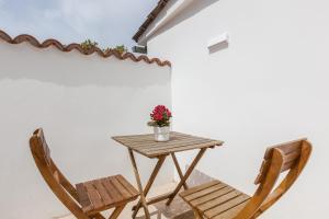 a wooden table with two chairs and a vase of flowers at Casita Palmeras in Canyelles +15 photos