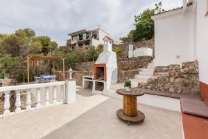 a patio with a fireplace on a house at Casita Palmeras in Canyelles