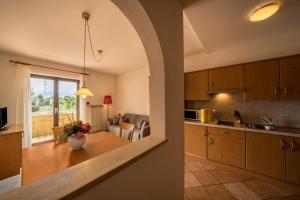 a kitchen and living room with a vase of flowers on a table at Weinsepphof Ferienwohnung 3 in Lana