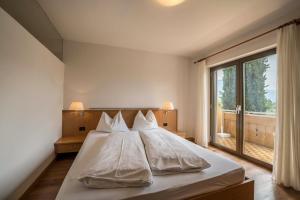 a bed in a bedroom with a large window at Weinsepphof Ferienwohnung 3 in Lana +20 photos