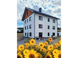 a white house with sunflowers in front of it at Ferienwohnung Mertens in Schmallenberg