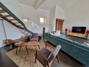 a living room with a green couch and chairs at Villa lavaudieu in Lavaudieu