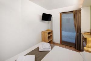 a small bedroom with a bed and a television at Chalet Emma Isolaccia in Valdidentro