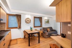 a kitchen and living room with a table and a couch at Chalet Emma Isolaccia in Valdidentro