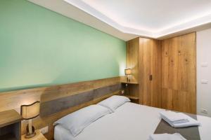 a bedroom with a white bed and a green wall at Chalet Emma Isolaccia in Valdidentro