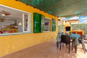 a patio with a table and chairs on a house at Buena Ventura Villa in Cala en Bosc +17 photos
