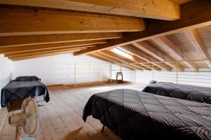 a attic room with two beds and a fan at Casa Zia Dani in Piantedo