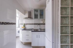 a white kitchen with white cabinets and a sink at Málaga Dream Apartment in Málaga +20 photos
