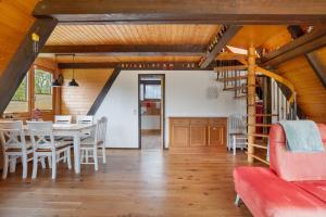 a dining room with a table and chairs and a staircase at Ferienhaus Bussardnest in Tennenbronn