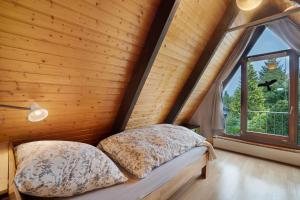 two beds in a room with a large window at Ferienhaus Bussardnest in Tennenbronn