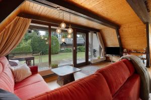 a living room with a red couch and a table at Ferienhaus Bussardnest in Tennenbronn