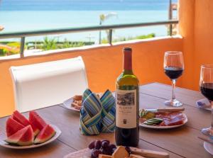 a bottle of wine sitting on a table with food and wine glasses at Fantastic beachfront apartment in Estepona