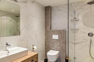 a bathroom with a shower and a toilet and a sink at Ferienwohnung Grubig in Ehrwald +12 photos