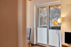 a room with a window and a desk and a television at Ferienwohnung Grubig in Ehrwald