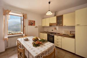 a kitchen with a table with fruits and vegetables on it at Casa dei Fiori in Casanova Lerrore