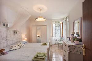 a bedroom with a large bed with a dresser and a bathroom at Casa dei Fiori in Casanova Lerrore +21 photos