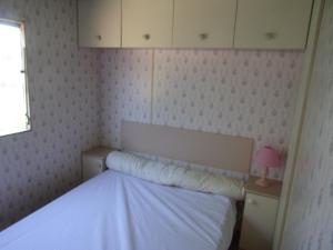 a small bedroom with a white bed and a window at Mobil'Home du Sancillon in Charentay