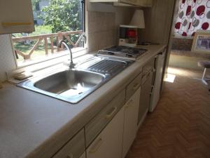 a kitchen with a sink and a stove and a window at Mobil'Home du Sancillon in Charentay