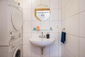 a white bathroom with a sink and a washing machine at Ferienwohnung Lichtblick in Grömitz +27 photos