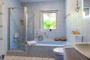 a bathroom with a tub and a toilet and a sink at Casa Conte in Mörlenbach +22 photos