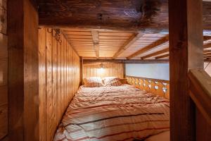 a large bed in a room with wooden walls at L'Escampette à la Fontanette in Saint-Pancrace