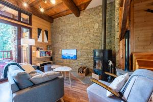 a living room with two couches and a brick wall at L'Escampette à la Fontanette in Saint-Pancrace