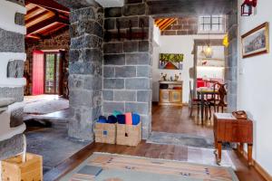 a living room with a stone fireplace and a table at Ponta da Amora in Ponta Garça