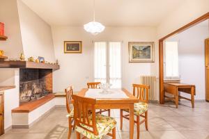 a dining room with a table and chairs and a fireplace at Holiday House Giuliana in Poggio a Caiano