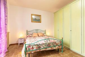 a bedroom with a green bed in a room at Holiday House Giuliana in Poggio a Caiano