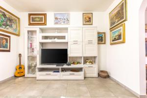 a white entertainment center with a flat screen tv at Holiday House Giuliana in Poggio a Caiano