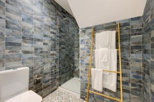 a bathroom with a toilet and a shower with blue tiles at Villa Xique 11 in Monchique +15 photos