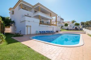 a villa with a swimming pool in front of a house at Villa do Lago in Albufeira