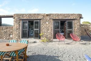 a table and chairs in front of a stone house at Estudio Pu in La Vegueta