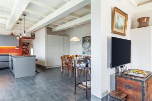a kitchen and living room with a table and a tv at Casa Lu in Massarosa