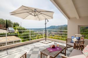 a patio with a table and an umbrella at Casa Lu in Massarosa