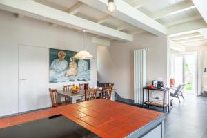 a dining room with a table and a painting on the wall at Casa Lu in Massarosa