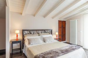 a bedroom with a large bed and two lamps at Casa Lu in Massarosa