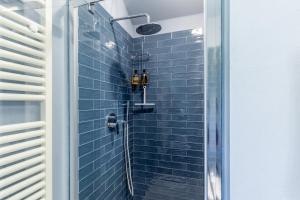 a bathroom with a shower with blue tiles at Casa Lu in Massarosa +18 photos