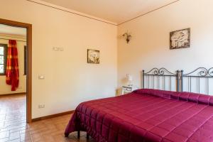 a bedroom with a bed with a purple bedspread at Casolare dei Fiori - Calla in Montecarlo +14 photos